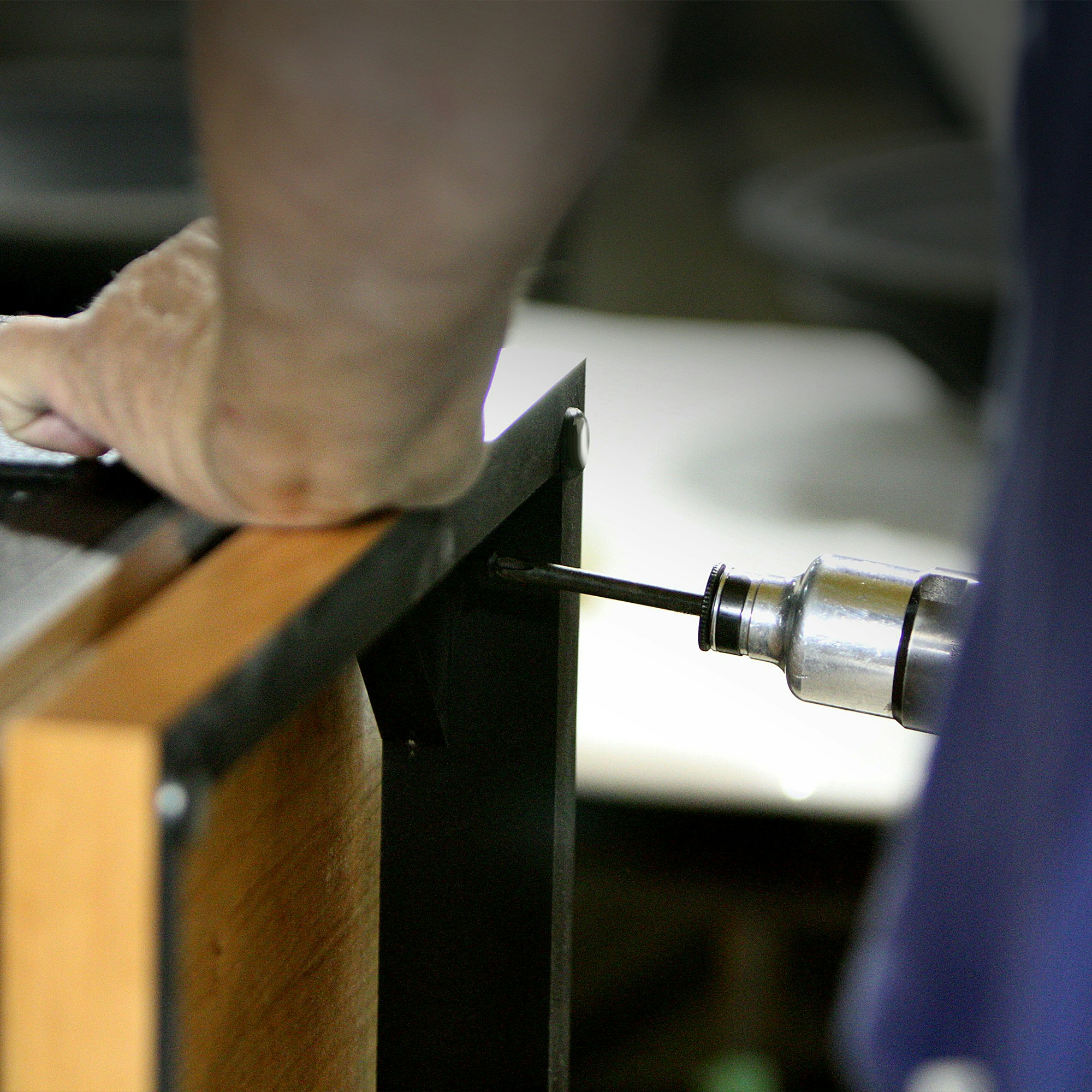 A close up view of a craftsman at the Hope Arkansas Klipsch Factory hand assembling a Heritage Speaker with a screwgun